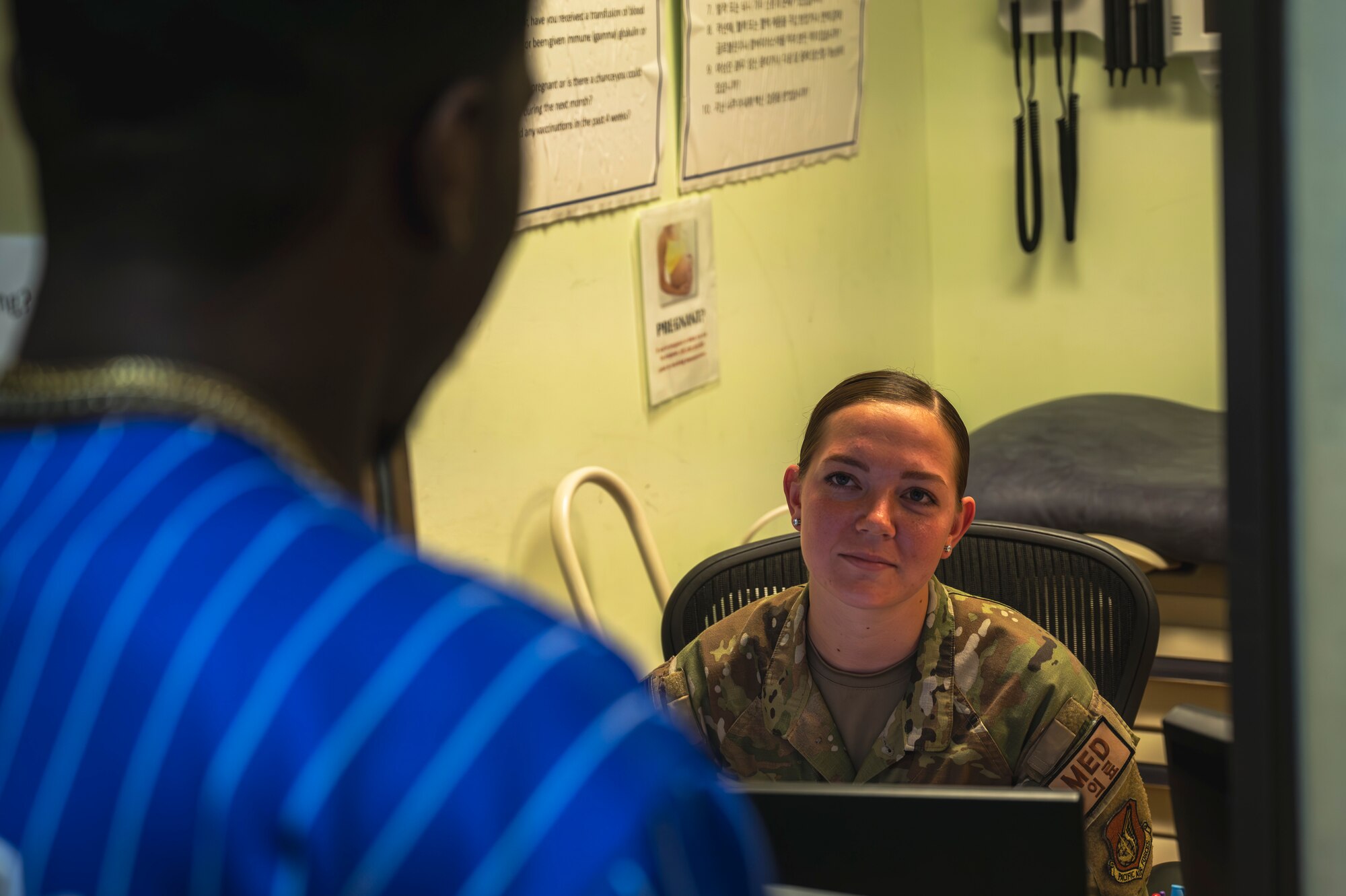 Senior Airman Emma Derosier, 8th Medical Group immunizations technician, speaks with a customer