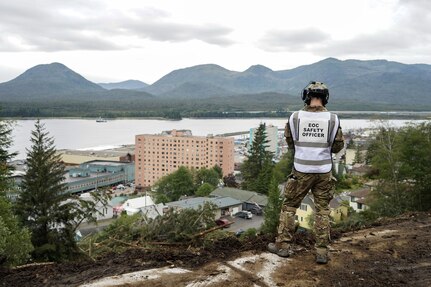 laska State Defense Force 2nd Lt. (AK) Matthew Nunnally, the acting Emergency Operations Center safety officer, surveys a debris field while responding to a major landslide in Ketchikan, Alaska, Aug. 27, 2024. Four Alaska Army National Guardsmen and two members of the Alaska State Defense Force mobilized on State Active Duty to assist with response and recovery efforts.