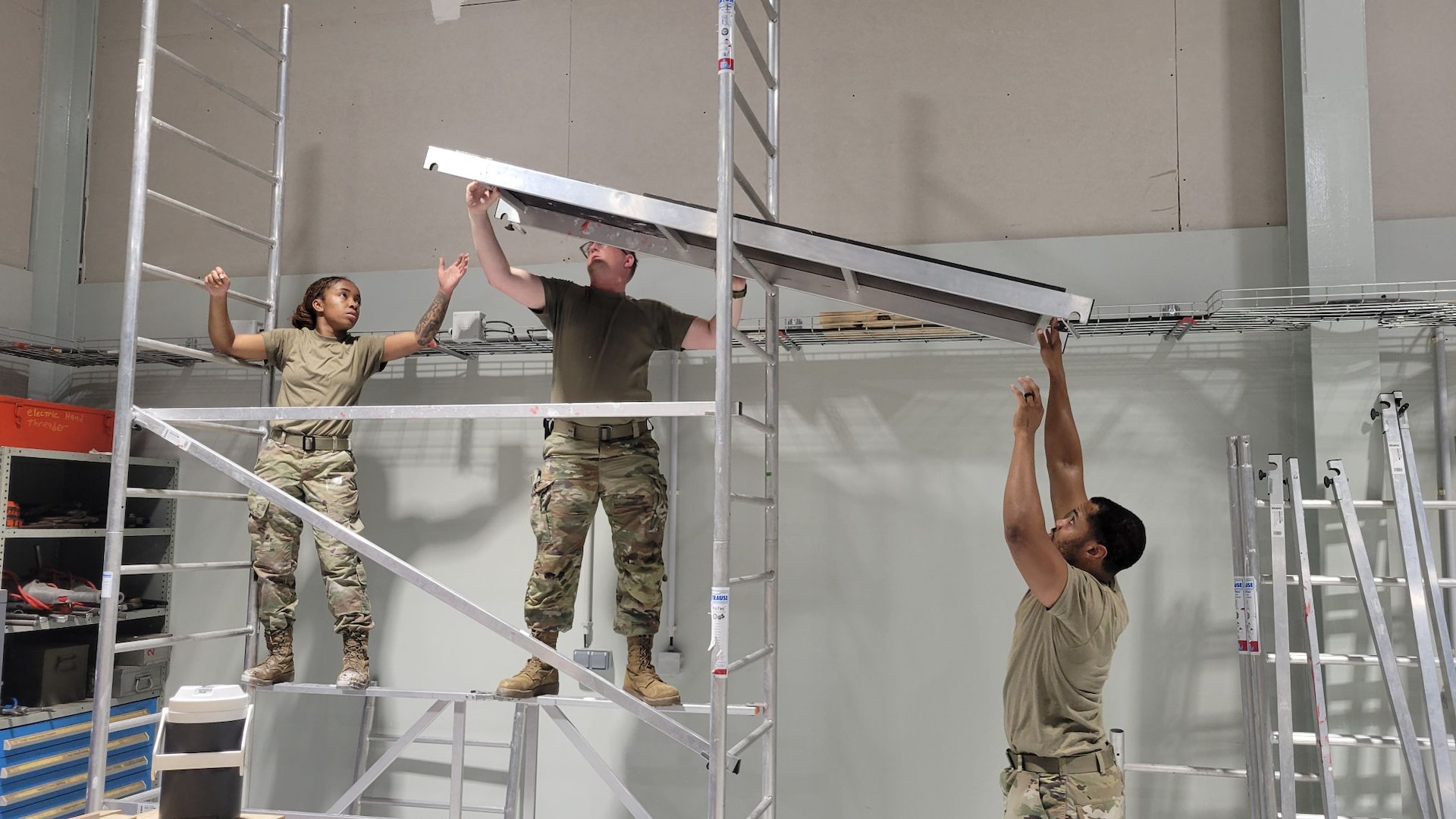 Three Airmen setting up scaffolding