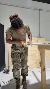 Airman cutting drywall sheet