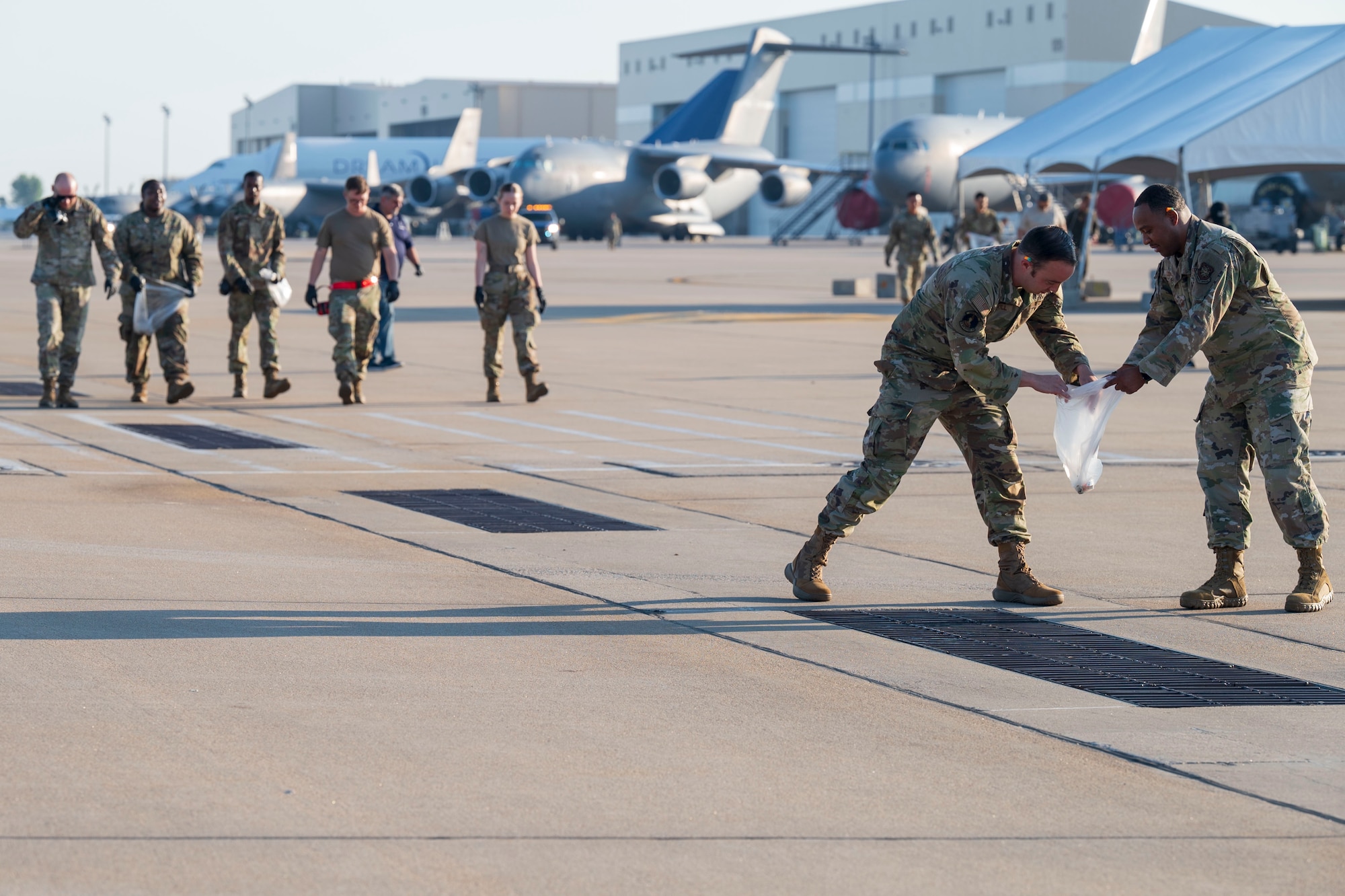 Airmen assigned to the 22nd Air Refueling Wing conduct a foreign object debris (FOD) walk following the Frontiers in Flight Air Show Aug. 26, 2024, at McConnell Air Force Base, Kansas. The FOD walk included Airmen from every group in the wing to clear the flightline of materials such as rocks, loose hardware and litter from the air show. (U.S. Air Force photo by Airman 1st Class Gavin Hameed)