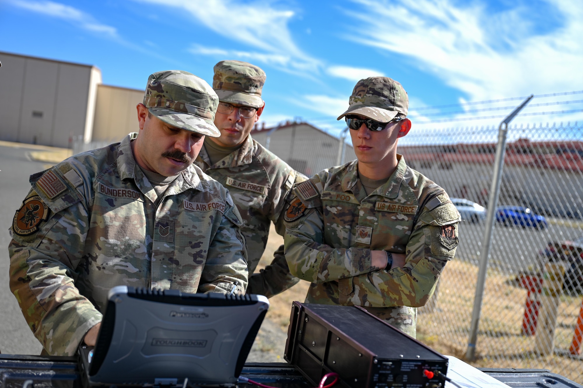 U.S. Air Force Tech. Sgt. Cody Bunderson, 87th Electronic Warfare Squadron Combat Shield avionics Electronic Warfare (EW) craftsman, left, U.S. Air Force Staff Sgt. Eric Johnson, 87th EWS Combat Shield avionics EW journeyman, center, and U.S. Air Force Staff Sgt. Nathan Foo, 87th EWS Combat Shield avionics EW journeyman, right, work to test a satellite connection during preparation for assessment at Travis Air Force Base, Cali, Aug. 5, 2024. Combat Shield supported the 336th Fighter Squadron by assessing their F-15 onboard EW systems during the exercise Bamboo Eagle 24-3. (U.S. Air Force photo by Capt. Benjamin Aronson)