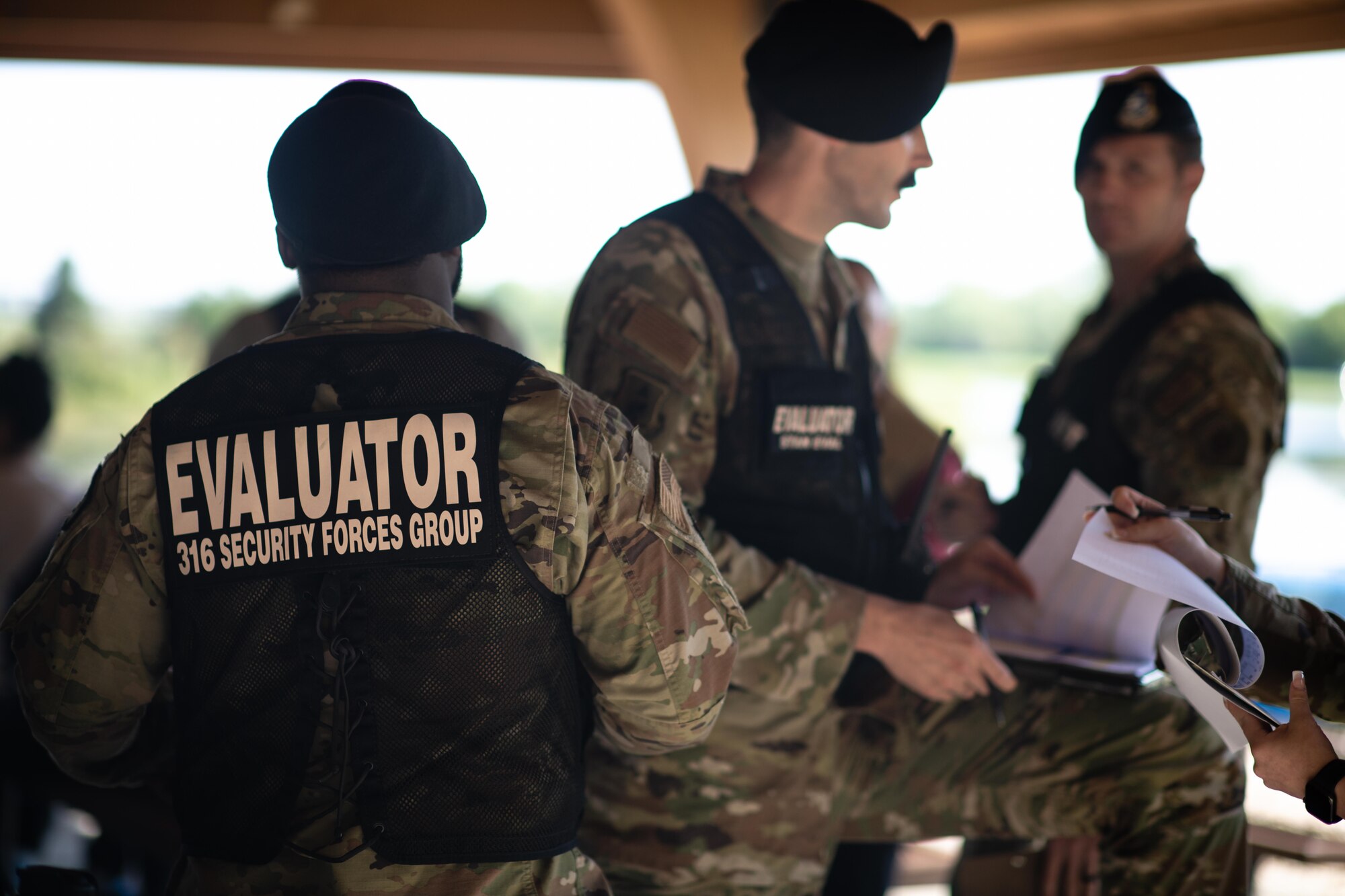 316th Wing inspection team members take nots during a domestic violence exercise.