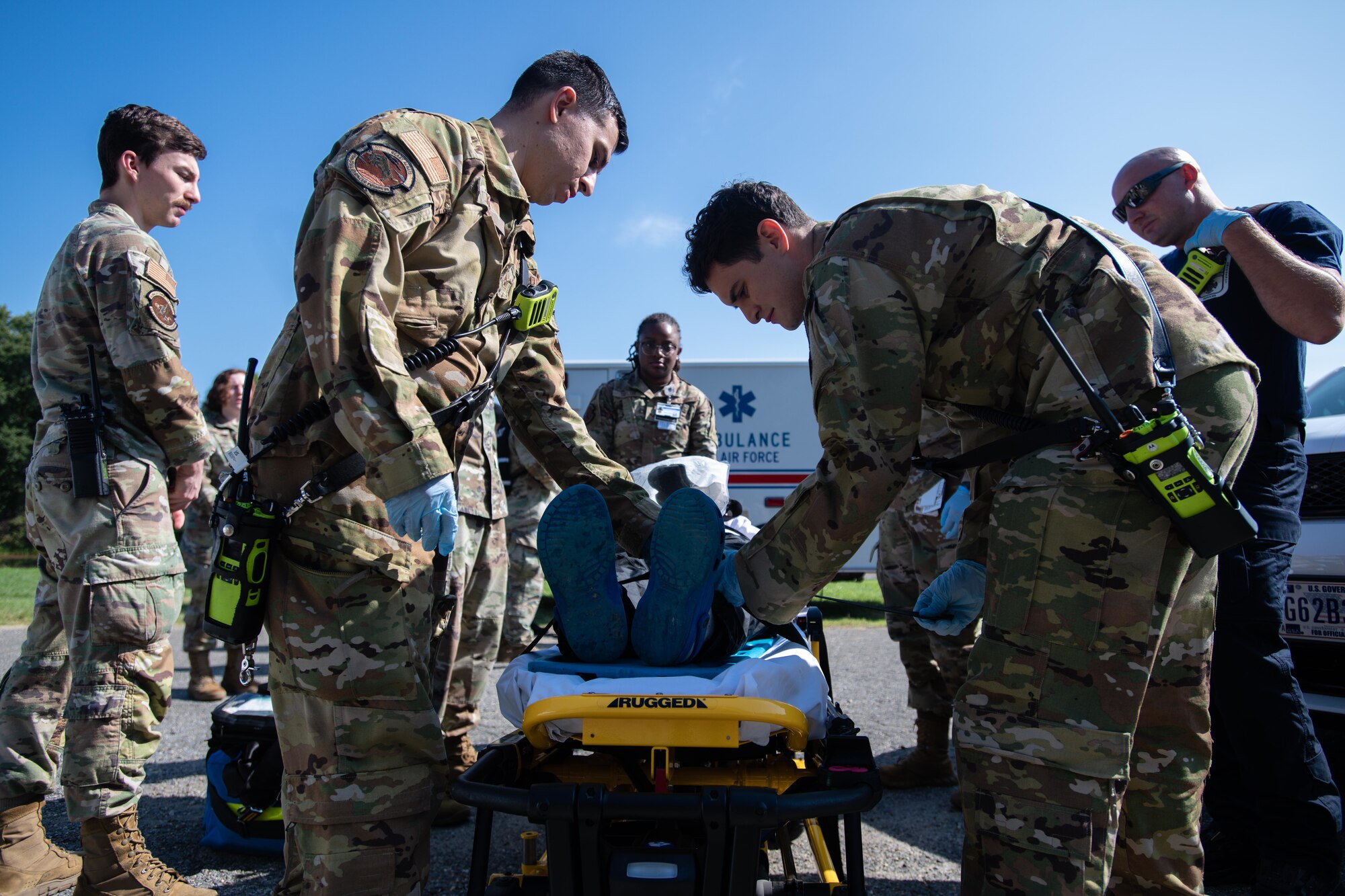 Airmen adjust the straps for a simulated head-wound.