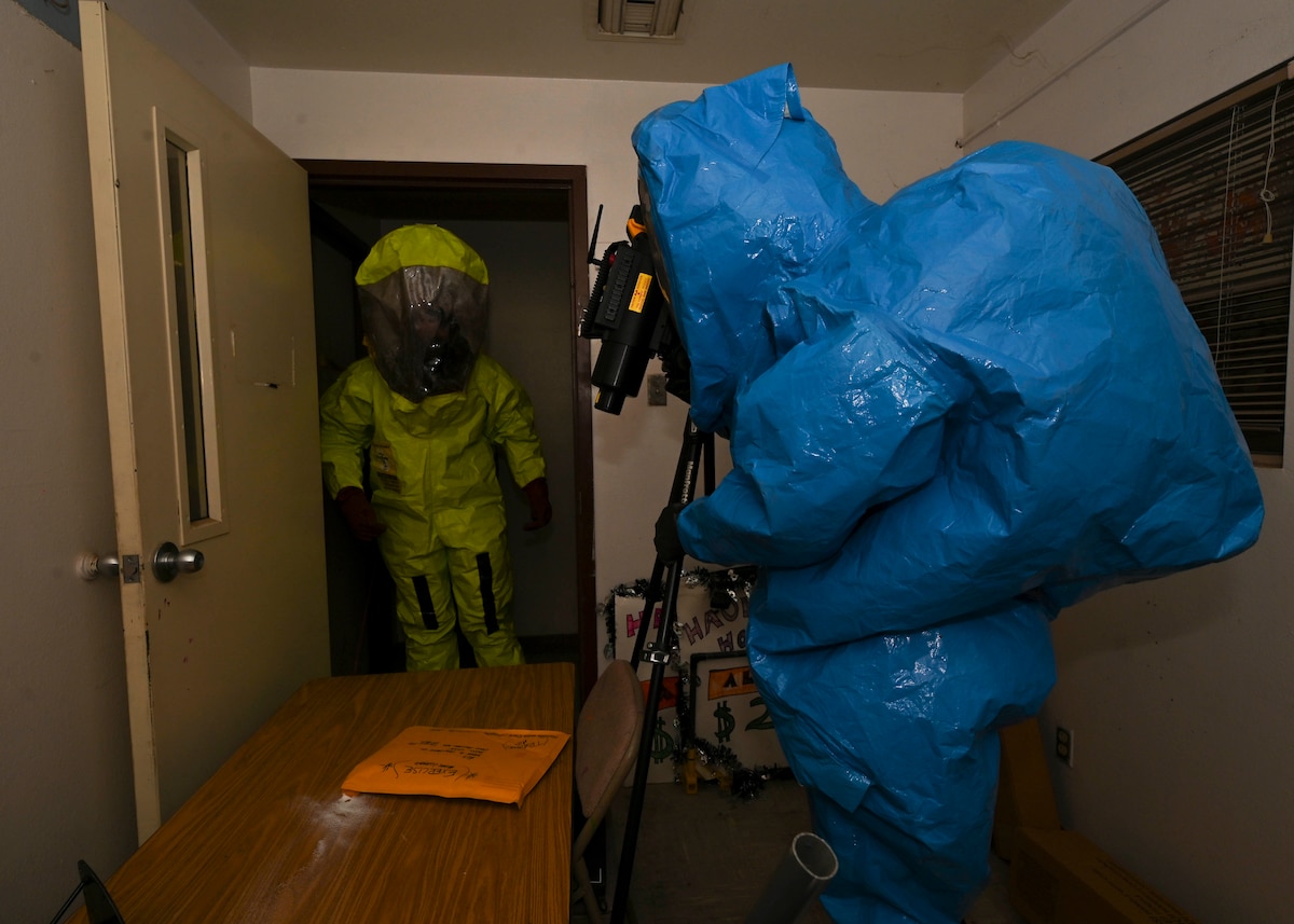 Men in hazmat suits set up an x-ray machine