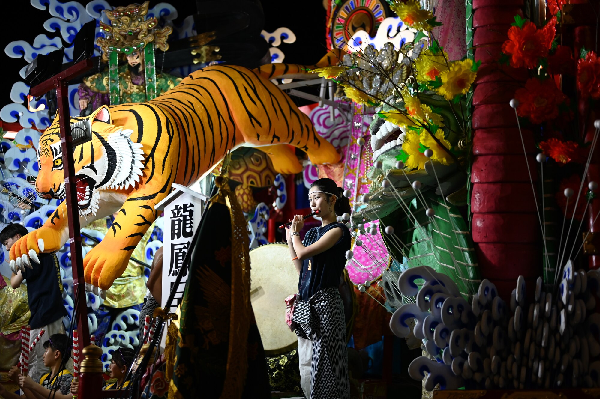 A participant of the Misawa City Festival plays a flute on top of a float at Misawa City,