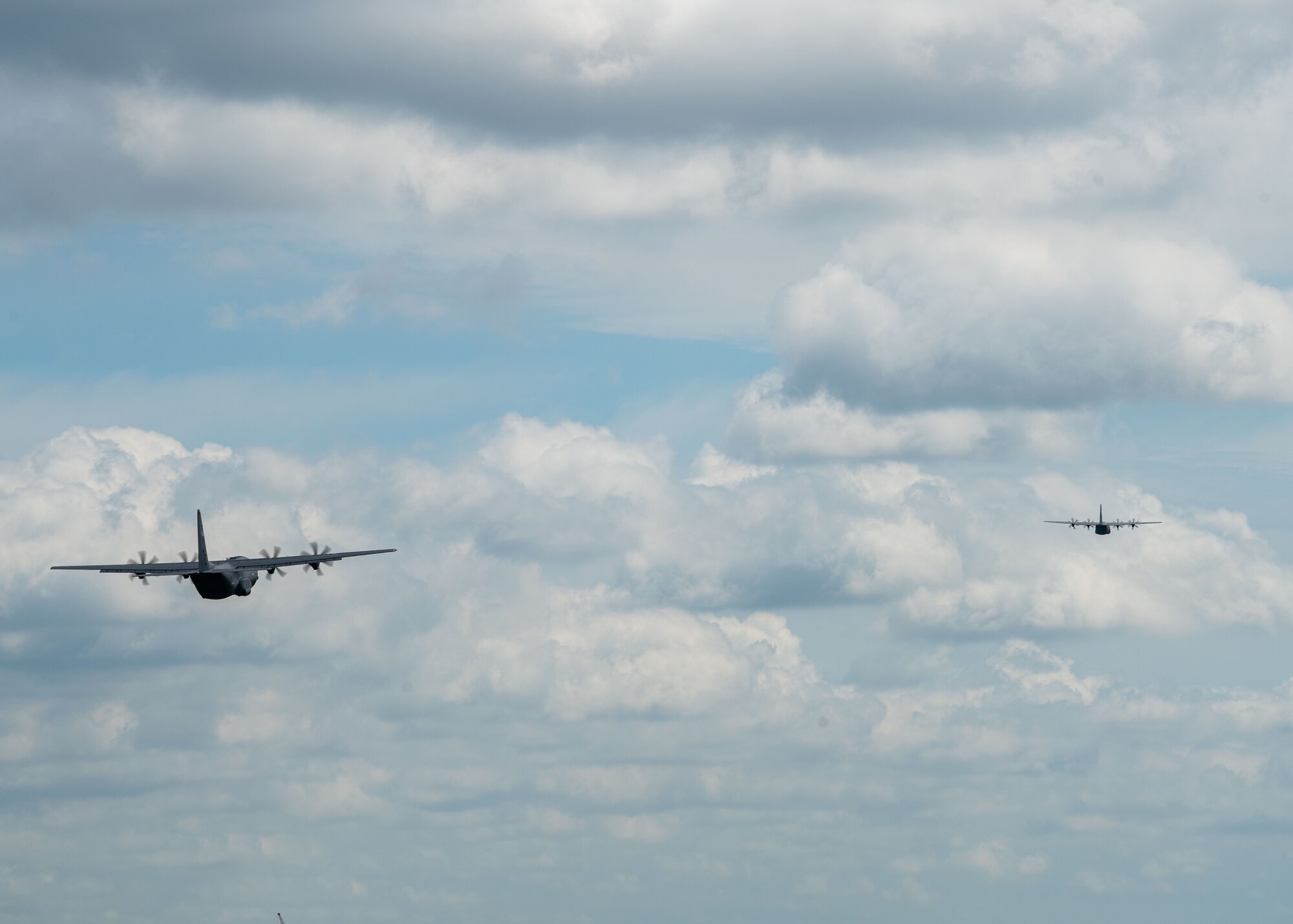 Two C-130J Super Hercules aircraft fly above Yokota.