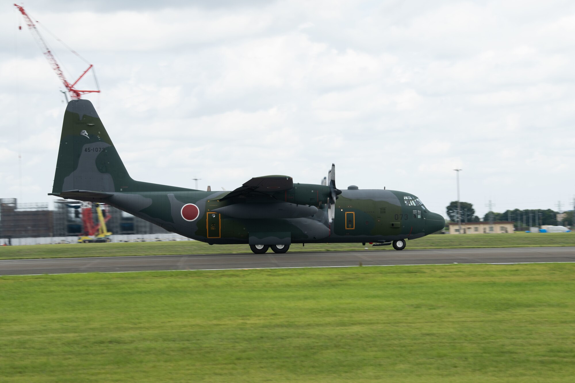 A Japan Air Self-Defense Force C-130H Hercules taxis down the flightline at Yokota.