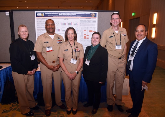 KISSIMMEE, Fla. – (Aug. 27, 2024) – Capt. Franca Jones, commander, Naval Medical Research Command (NMRC) and Command Master Chief Phillip Jean-Gilles with leadership of Naval Medical Research Unit (NAMRU) San Antonio during Poster Session One on day two of the 2024 Military Health System Research Symposium (MHSRS) held at the Gaylord Palms Resort and Convention Center. The MHSRS brings together military, government, academia, and industry experts for four days of critical conversations and intensive idea sharing. Presenters will share their latest research findings and challenges on topics including combat casualty care, military operational medicine, clinical and rehabilitative medicine, medical simulation and information sciences, military infectious diseases, and the radiation health effects. NAMRU San Antonio is one of the leading research and development laboratories for the U.S. Navy under the Department of Defense (DoD) and is one of eight subordinate research commands in the global network of laboratories operating under the Naval Medical Research Command in Silver Spring, Md.  Its mission is to conduct gap driven combat casualty care, craniofacial, and directed energy research to improve survival, operational readiness, and safety of DoD personnel engaged in routine and expeditionary operations. (U.S. Navy photo by Burrell Parmer, NAMRU San Antonio Public Affairs/Released)