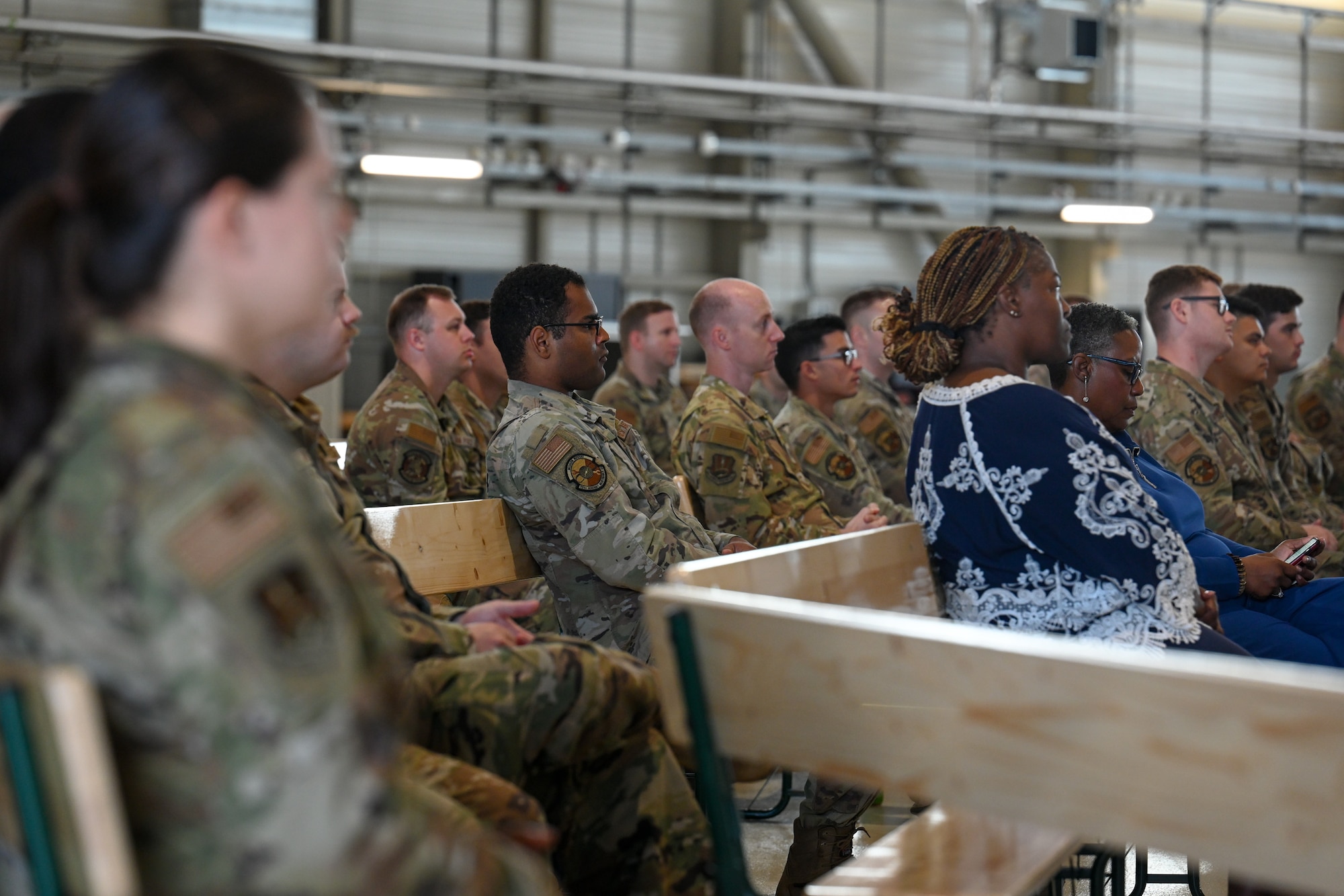 Members assigned to the 521st Air Mobility Operations Wing listen to a Warrior Heart keynote speech from retired U.S. Air Force Chief Master Sgt. Anthony Brinkley, inside of Hangar 5 on Ramstein Air Base, Germany, August 29, 2024.