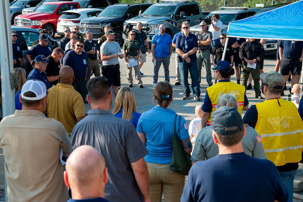 Emergency first responders, law enforcement, and U.S. Army Corps of Engineers Louisville District employees listen to a safety brief from U.S. Coast Guard Captain Heather R. Mattern, sector commander, Sector Ohio Valley, Eighth Coast Guard District, prior to a mock emergency exercise at McAlpine Locks and Dam July 31, 2024.