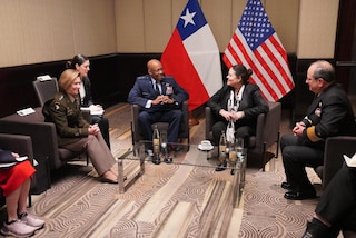 Military personnel sit in chairs for a discussion.