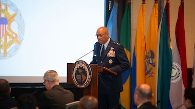 A military person speaks a podium.