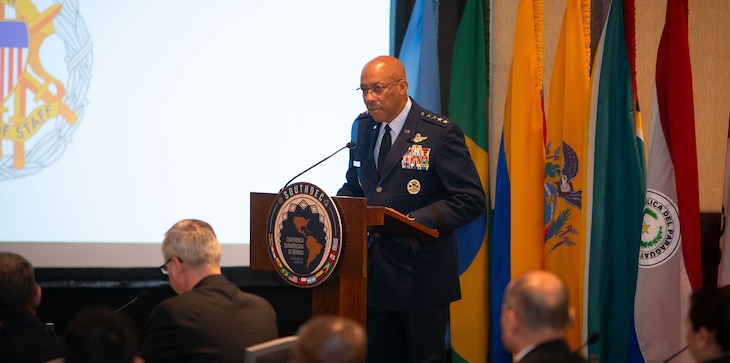 A military person speaks a podium.