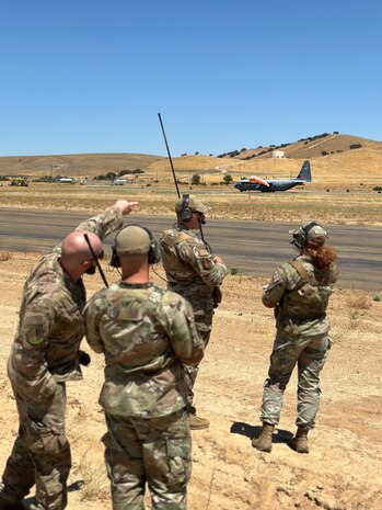 U.S. Air Force landing zone safety officers from the 9th Operations Support Squadron, Beale Air Force Base, await a C-130J Super Hercules from the 146th Airlift Wing, Channel Islands Air National Guard Station, to taxi out for departure from the Landing Zone at Camp Roberts, California, Aug. 8, 2024.