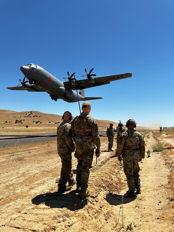 U.S. Air Force landing zone safety officers from the 9th Operations Support Squadron , Beale Air Force Base, watch the safe departure of a C-130J Super Hercules from the 146th Airlift Wing, Channel Islands Air National Guard Station, and begin scanning the airspace to ensure safe and efficient operations for all aircraft under their control on the Landing Zone at Camp Roberts, California, Aug. 8, 2024.