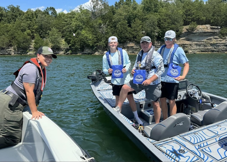 U.S. Army Corps of Engineers ranger Lisa Santiago (left) rewards local fisherman on J. Percy Priest Lake with a gift for wearing their lifejackets and boating responsibly.