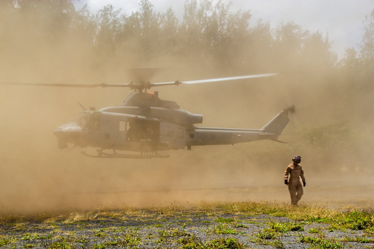 Lance Cpl. Stephanie Belanger, a bulk fueler with Marine Wing Support Detachment 24, and a 24-year-old native of Brentwood, N.H., clears the area after ground guiding the pilots of a UH-1Y Huey helicopter out of the forward arming and refueling point at Marine Corps Training Area Bellows, Hawaii, May 6, 2014. Marine Aircraft Group 24 conducted a max launch of 11 total UH-1Y Huey and AH-1W SuperCobra helicopters assigned to Marine Light Attack Helicopter Squadron 367 and CH-53E Super Stallion helicopters assigned to Marine Heavy Helicopter Squadron 463 in an effort to increase unit cohesion and camaraderie within the MAG. While HMLA-367 and HMH-463 conducted operations in the air, Marine Wing Support Detachment 24 and Marine Aviation Logistics Squadron 24 were on the ground to provide forward arming and refueling points, giving MAG-24 a chance to work as a whole. After conducting flight operations, the aircraft returned to MCAS Kaneohe Bay and completed their max launch with a flyby over Marine Corps Base Hawaii before landing. (U.S. Marine Corps photo by Lance Cpl. Matthew Bragg)