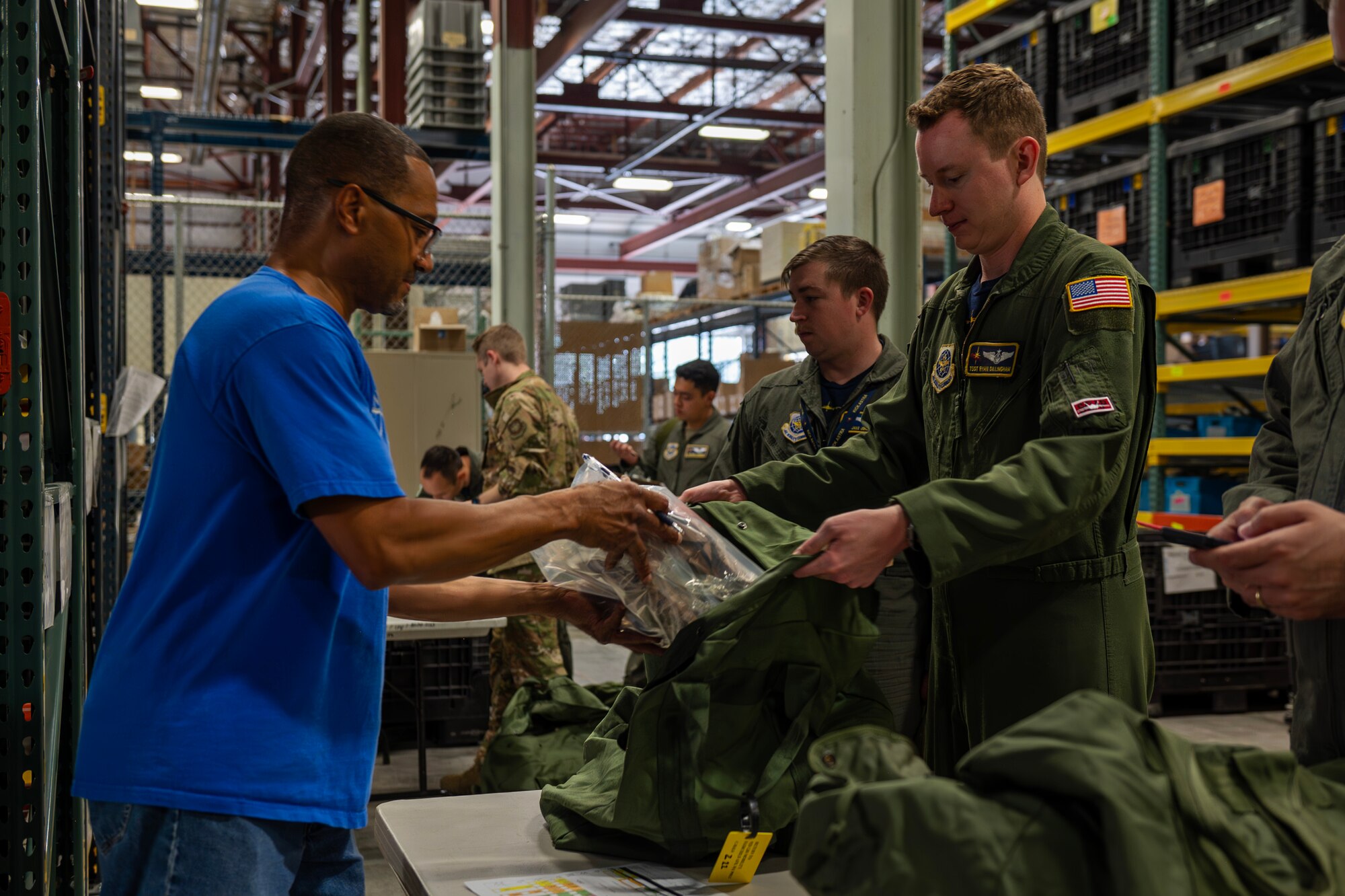 Tech. Sgt. Ryan Dillingham, a flight chief assigned to the 97th Air Refueling Squadron, receives and packs items into his deployment bag at Fairchild Air Force Base, Aug. 9, 2024. Airmen receive multiple bags containing various clothing items and gear that they may need in a deployed environment. Airmen assigned to the 92nd Air Refueling Wing deployed outside of the normal Air Force Force Generation cycle as part of U.S. force posture changes in the U.S. Central Command area of responsibility to mitigate the possibility of regional escalation. (U.S. Air Force photo by Senior Airman St Marks)