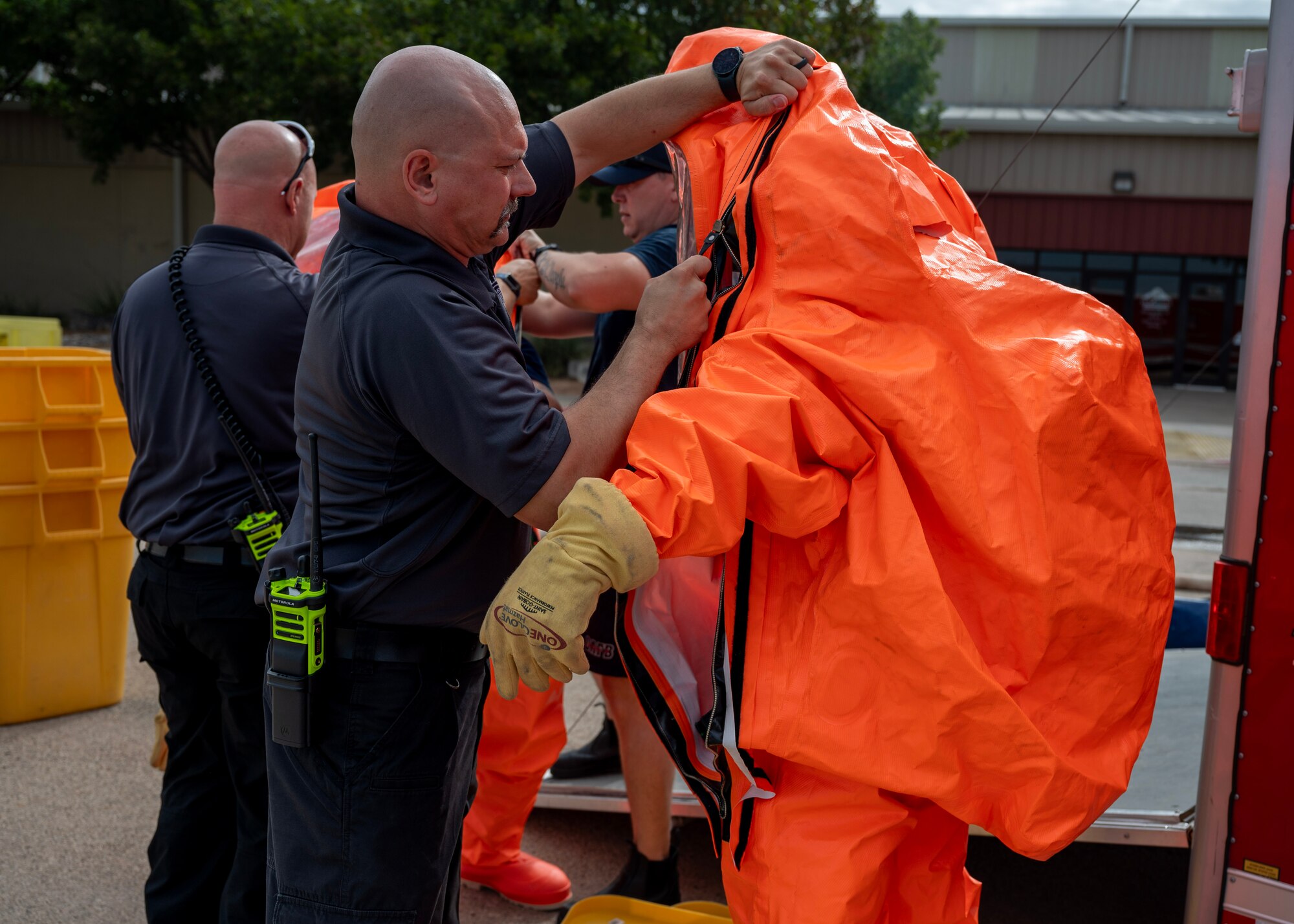 Alan Herbert, 17th Civil Engineer Squadron assistant fire chief, zips personal protective equipment at the Spur Arena, San Angelo, Texas, Aug. 27, 2024. PPE provides a barrier against harmful materials, protecting responders from potential health hazards and ensuring effective management of the situation. (U.S. Air Force photo by Senior Airman Sarah Williams)