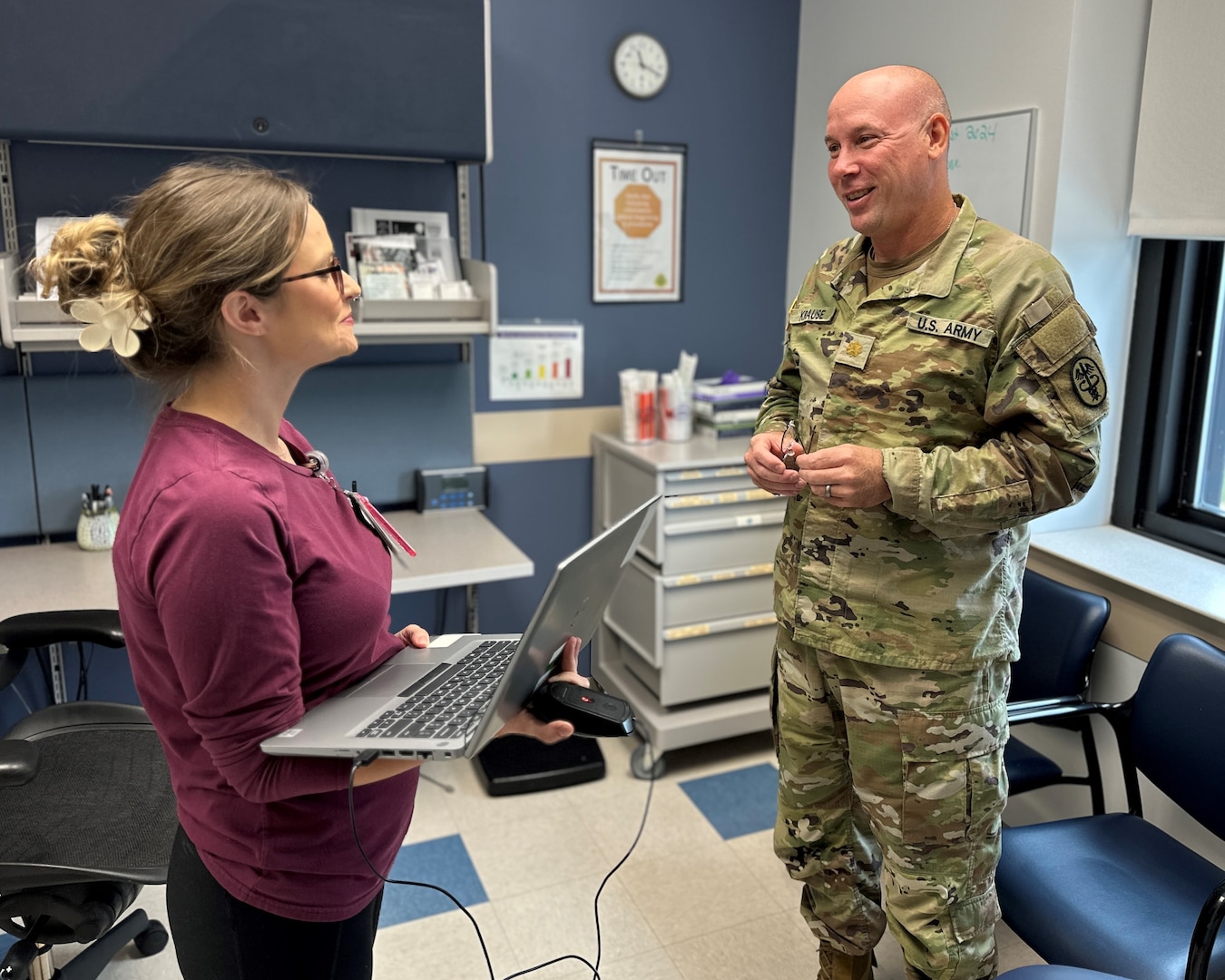 a male and female healthcare professional talking in an exam room