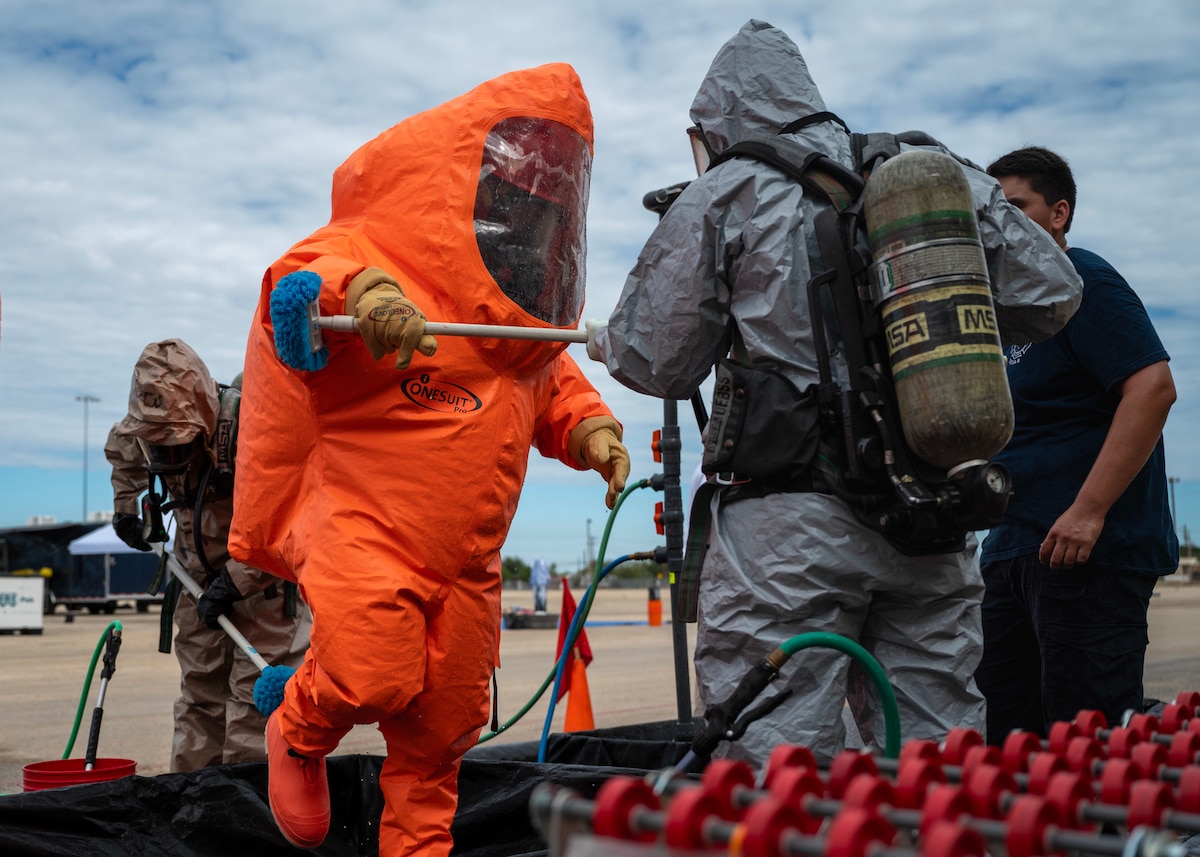Zachary Kirkish, 17th Civil Engineer Squadron firefighter, is scrubbed in the decontamination zone at the Spur Arena, San Angelo, Texas, Aug. 27, 2024. Decontamination is essential for ensuring that hazardous materials are contained and neutralized, safeguarding the health of responders and preventing further environmental damage. (U.S. Air Force photo by Senior Airman Sarah Williams)