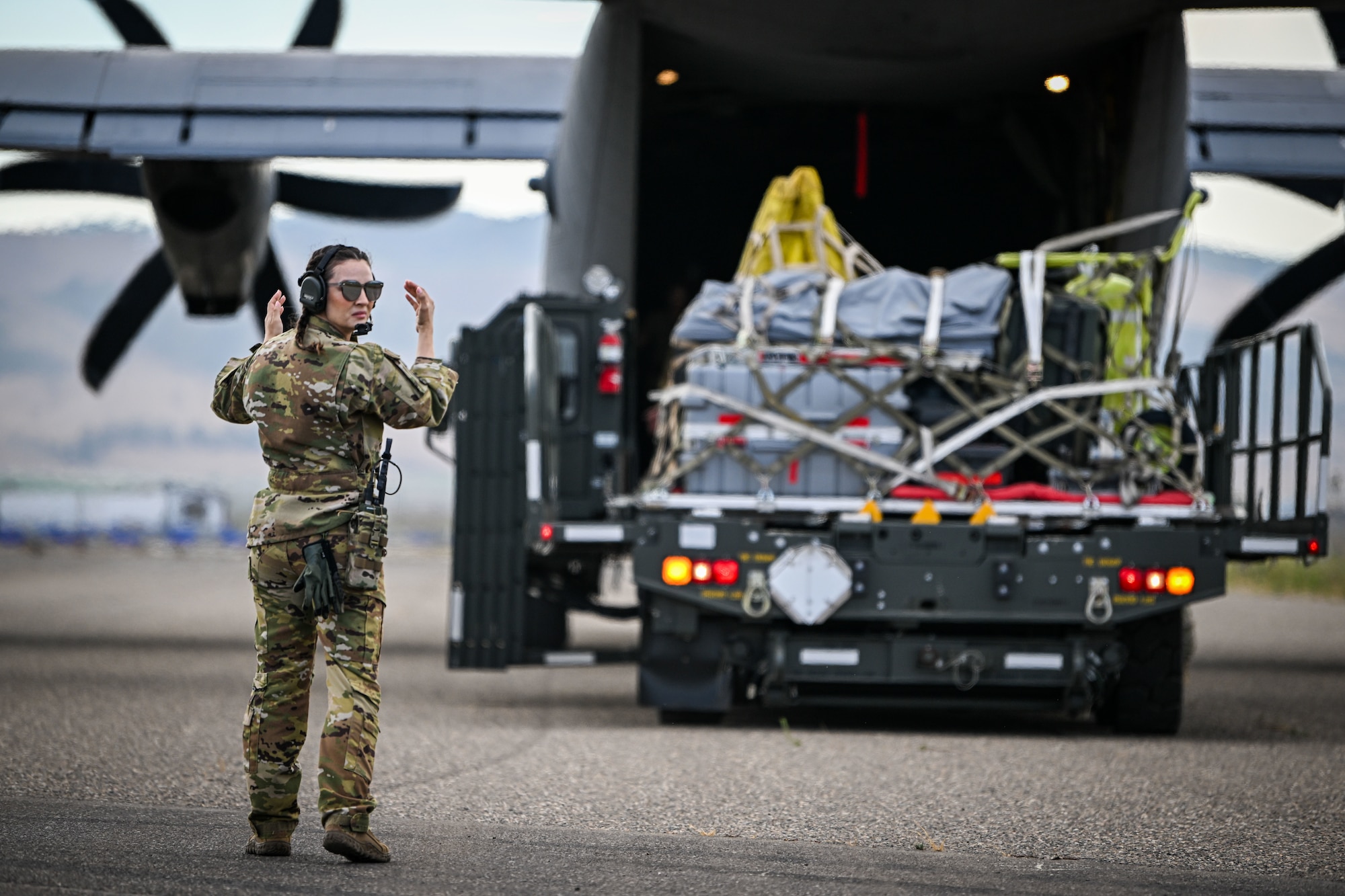 An U.S. Air Force C-17 Globemaster III loadmaster marshals a truck carrying maintenance support items for the F-35A Lightning II during Exercise Agile Flag 24-3 at Santa Maria, Aug. 3, 2024. During AGILE FLAG 24-3, the 23rd Wing provided the Air Expeditionary Wing leadership element, the Command-and-Control Force Element, and the Airbase Squadron at two separate locations exercising rapid insertion into theaters, establishing logistics and communications with theater C2, receipt of follow-on forces, mission generation, and combat power projection across all domains, while making critical decisions needed to remain agile. (U.S. Air Force photo by 2nd Lt. Benjamin Williams)