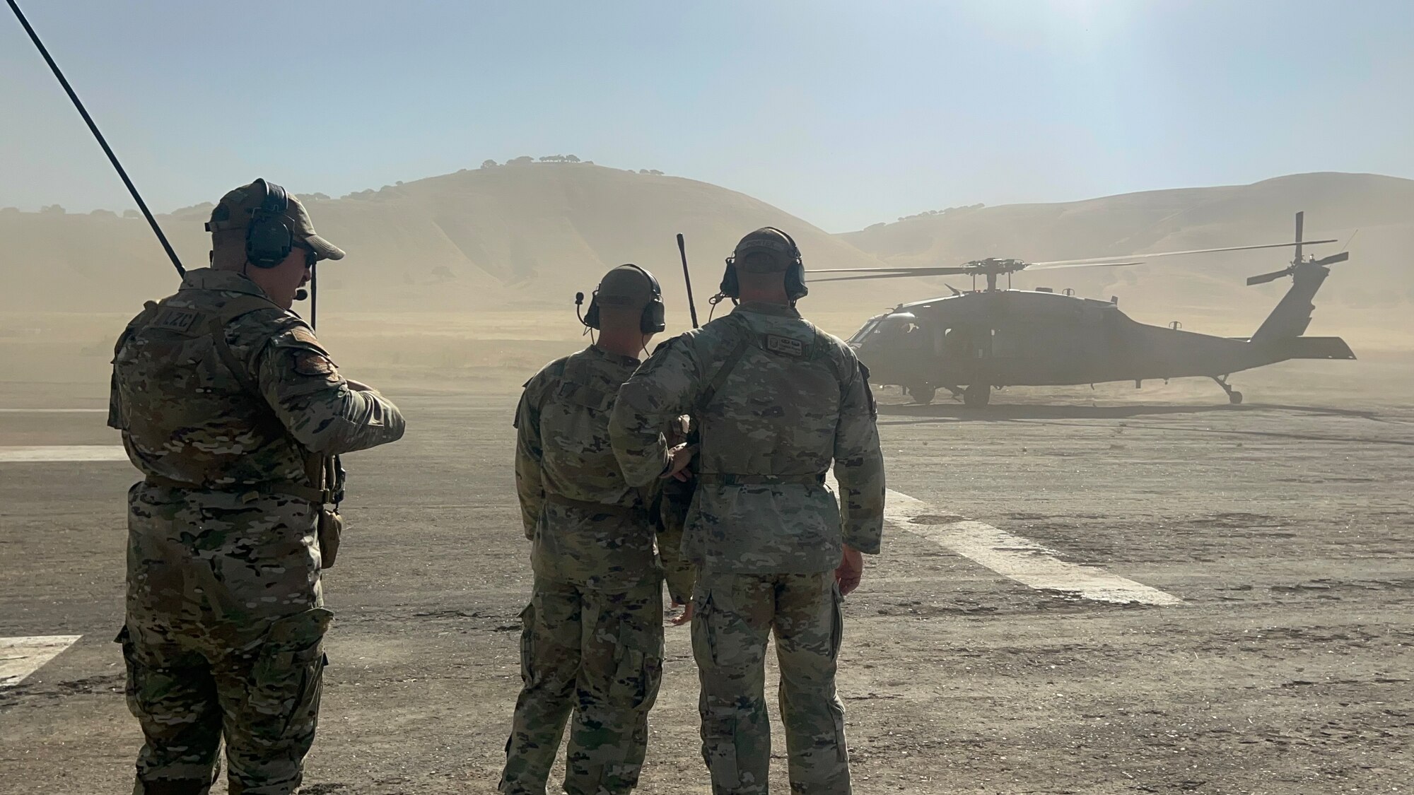 U.S. Air Force Tech. Sgt. David Rost, 9th Operational Support Squadron landing zone controller (left), Master Sgt. Cameron Piontek, 9th OSS landing zone controller, and Staff Sgt. Joseph Hasenauer, 9th OSS landing zone safety officer, from Beale Air Force Base, taxi a pararescue HH-60 Black Hawk from the 129th Rescue Squadron, Moffet Federal Airfield, to park on the Landing Zone at Camp Roberts, California, Aug. 8, 2024.