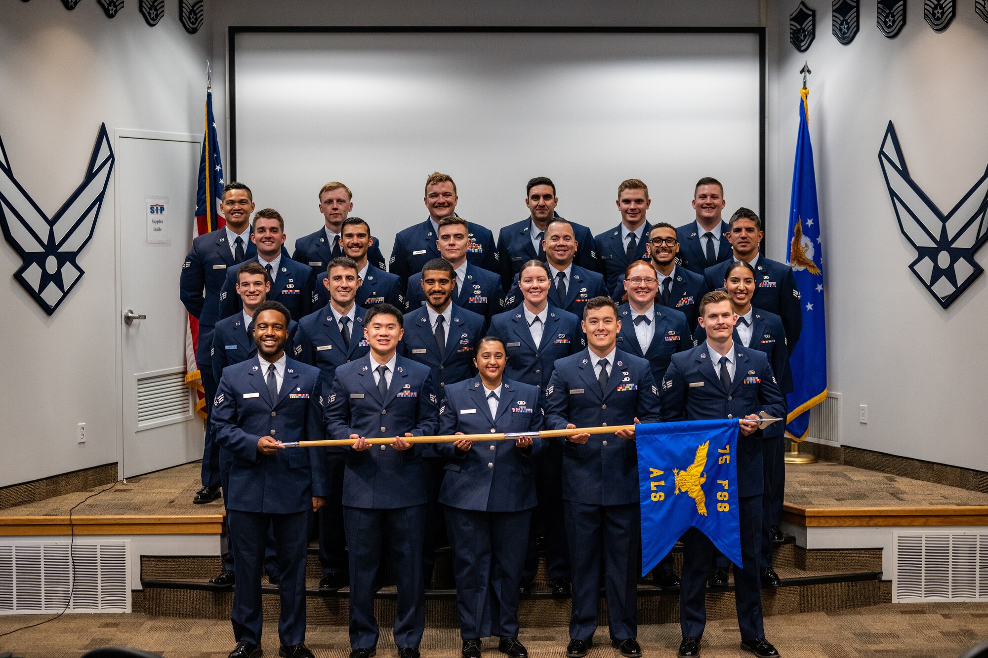 Military members in dress blues stand in formation