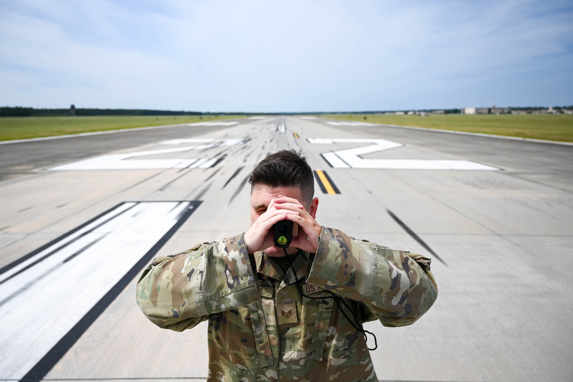 Airman uses a rangefinder on the flightline.