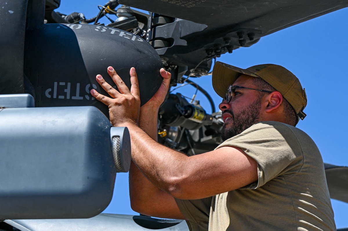 U.S. Air Force Senior Airman Sebastian Otero, 55th Rescue Generation Squadron crew chief assists in removing parts from a HH-60W Helicopter at Fort Huachuca, Arizona, Aug. 27, 2024. The 55th RGS assisted in ensuring military operations succeeded, such as civil search and rescue, disaster relief, international aid, emergency medical evacuation and counter-drug activities. (U.S. Air Force photo by Senior Airman Andrew Garavito)