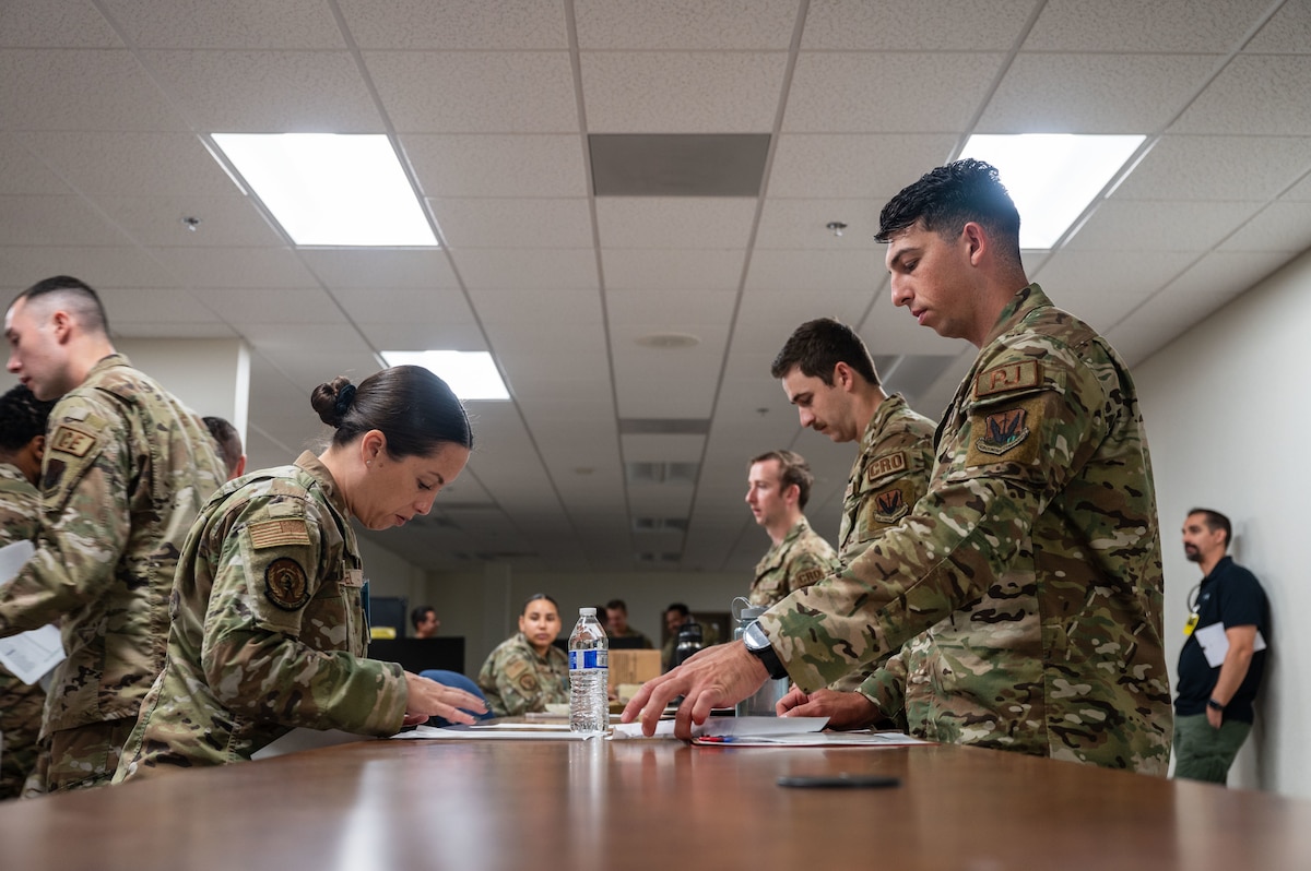 U.S. Airmen review their key documents for deployment during Exercise Mosaic Lightning 24-02 at Davis-Monthan Air Force Base, Arizona, Aug. 23, 2024. Mosaic Lightning was a wing wide readiness exercise that certified the ability to quickly deploy and respond to various types of adversary attacks. (U.S. Air Force photo by Airman 1st Class Jasmyne Bridgers-Matos)