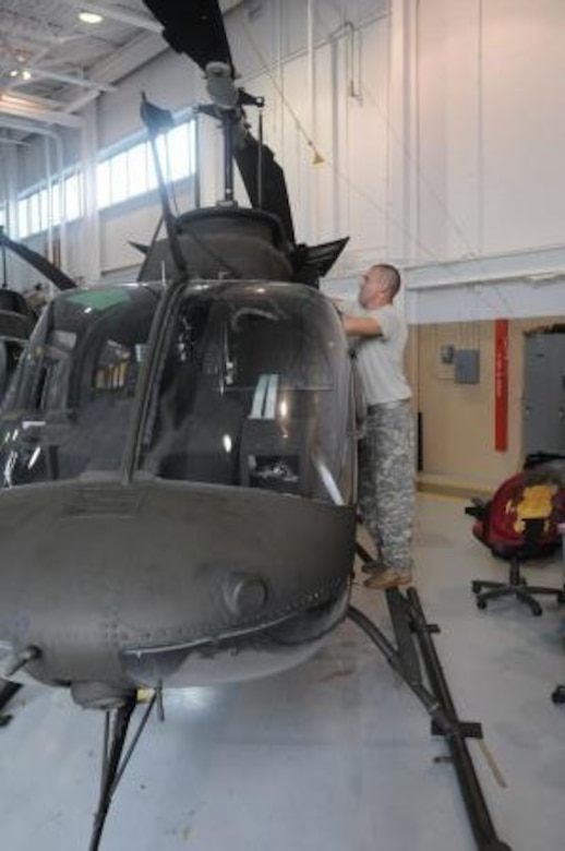 Spc. Tim Amyx with Charlie Company, 1st Battalion, 376th Aviation, works on a OH-58 helicopter at the Army Aviation Support Facility in Frankfort, Ky., Sept. 18, 2012. Because of the increase in maintenance requests, some soldiers were brought on full time to help handle the workload.