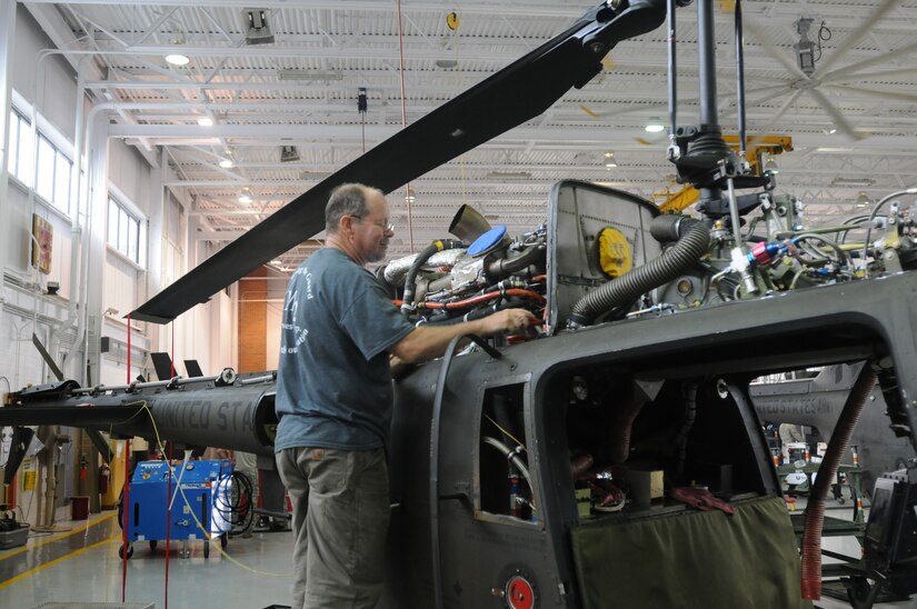 Glenn Cartwright, a civilian contractor, works to repair a OH-58 helicopter at the Army Aviation Support Facility in Frankfort, Ky., Sept. 24, 2012. In addition to contractors, several soldiers have been employed full-time to help with the increased workload of helicopter maintenance.