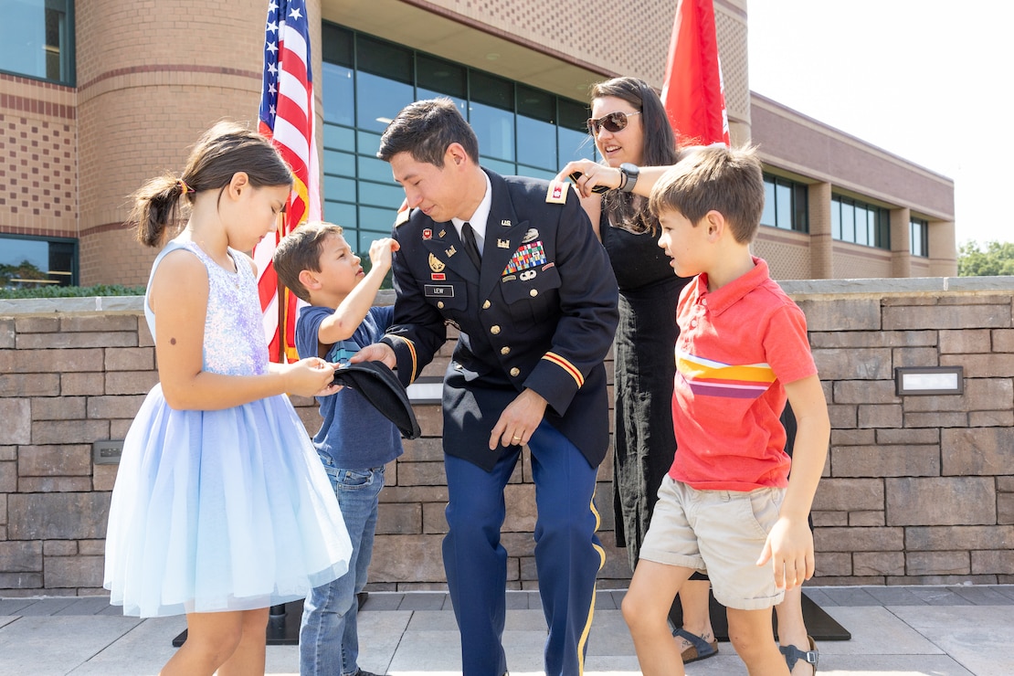 A man's children and wife pin on his new rank.