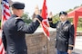 One man in uniform administering the oath of office to another man in uniform.