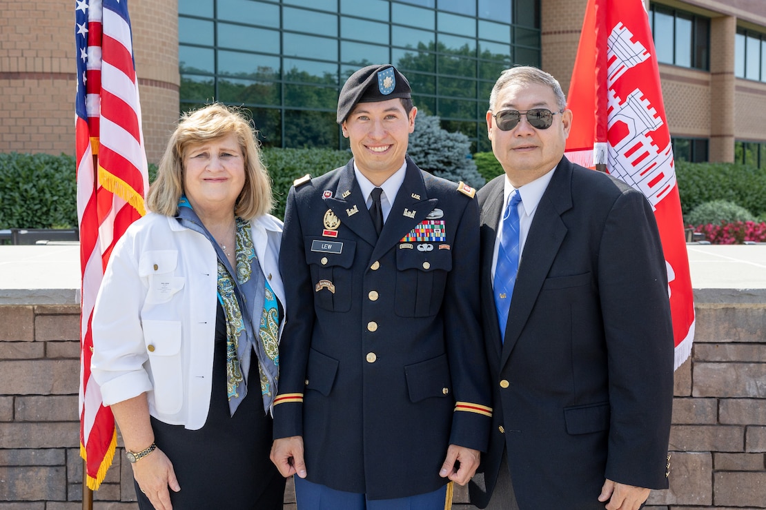 Man in uniform poses with his mother and father