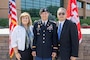 Man in uniform poses with his mother and father