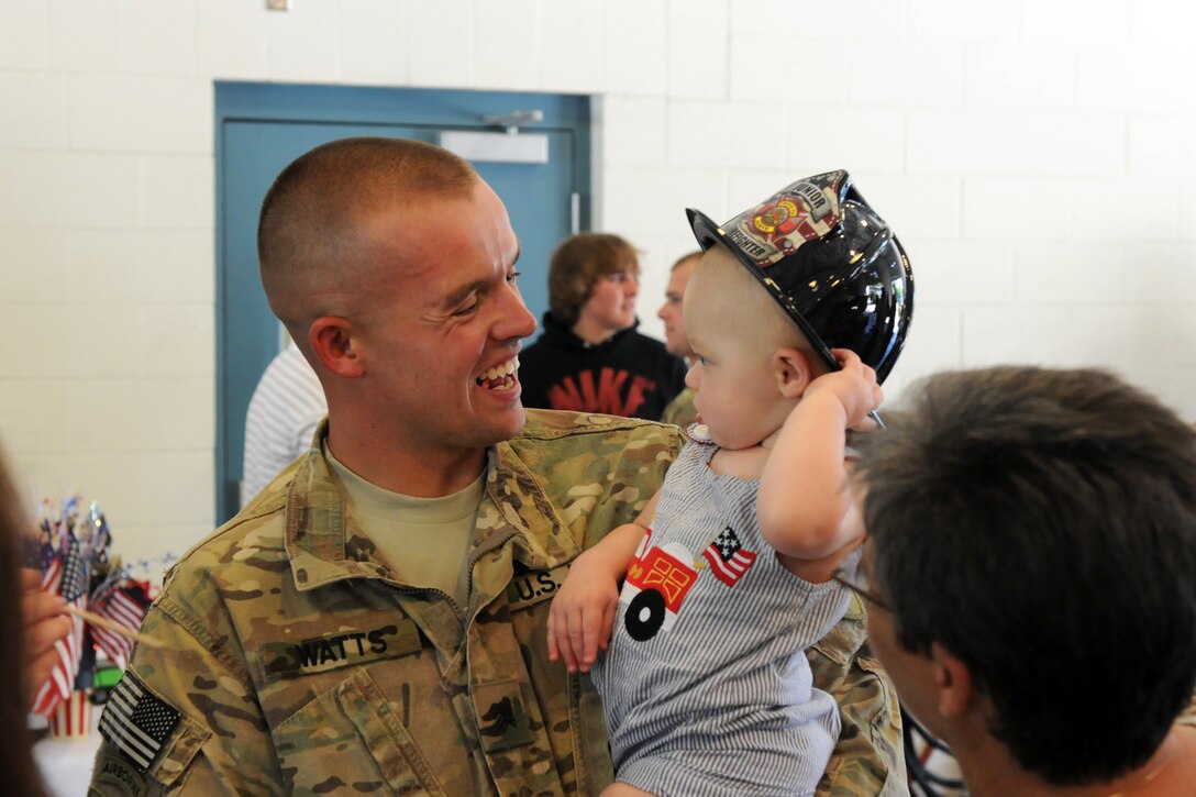 Sgt. Aaron Watts of Versailles, Ky., shares a moment with his son, Cameron, during the welcome home ceremony for the 176th Engineer Firefighting Team at the Wendell H. Ford Regional Training Center in Greenville, Ky., Sept. 11, 2012.  Watts and his unit deployed to Afghanistan exactly one year before, Sept. 11, 2011 in support of Operation Enduring Freedom.