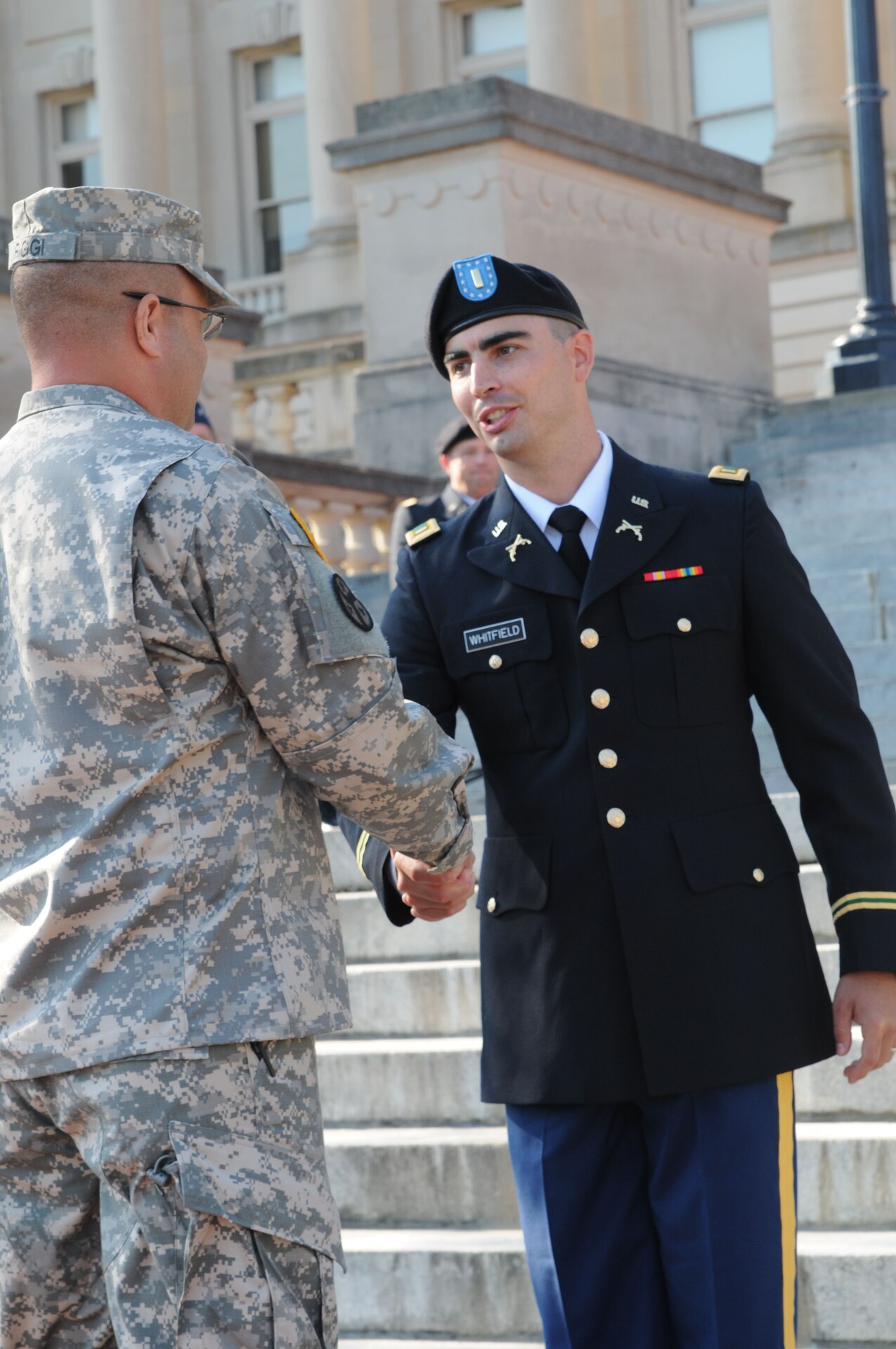 Staff Sgt. John Riggi shakes hands with newly promoted 2nd. Lt. Joshua Whitfield during the 238th Regiment's OCS Commissioning Ceremony at the State Capitol in Frankfort, Ky., Aug 25. Class 54-12 graduated 11 new lieutenants to serve in the Kentucky Army National Guard.