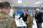 Defense Logistics Agency Land and Maritime Electronics Engineer Jeremiah Jones (left) and Product Test Center Chief John Elavsky (right) brief Air Force Maj. Gen. David Sanford (center) about battery lab capabilities during the logistics operations director’s site visit Aug. 21.