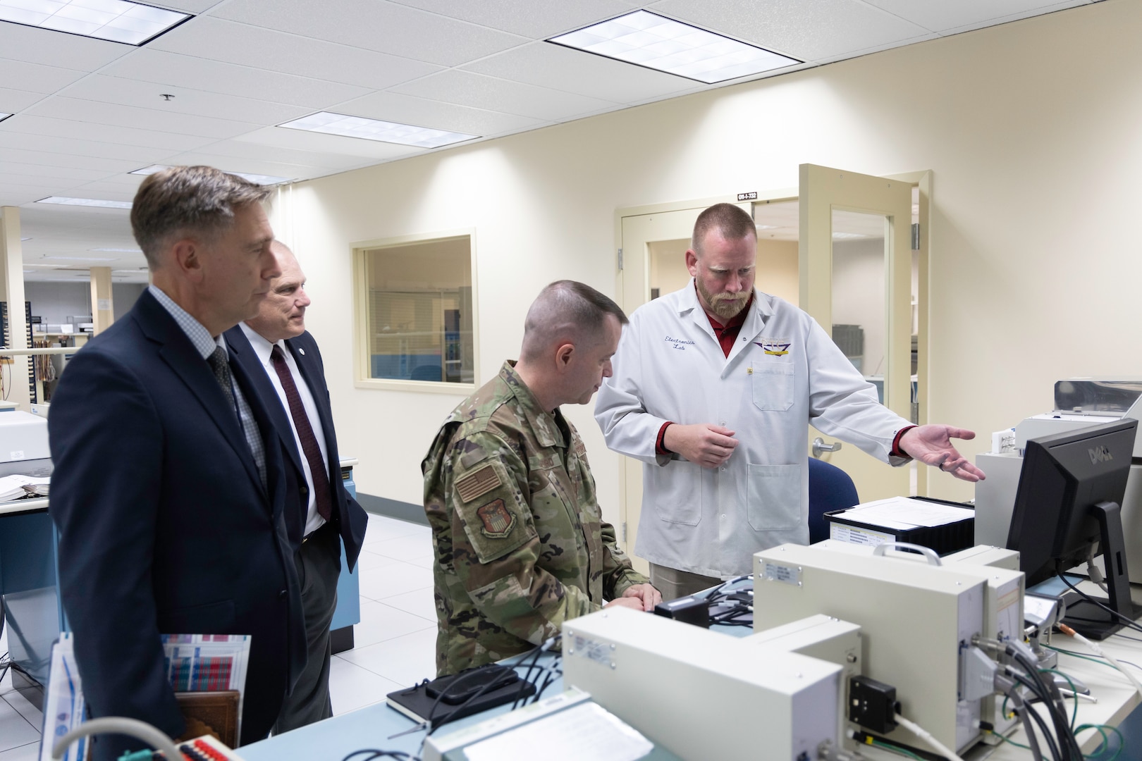 Rob Retkofsky (left), a technician in the Product Test Center’s electronics testing lab, demonstrates microcircuit testing procedures to Air Force Maj. Gen. David Sanford (center) during the DLA logistics operations director’s site visit Aug. 21.