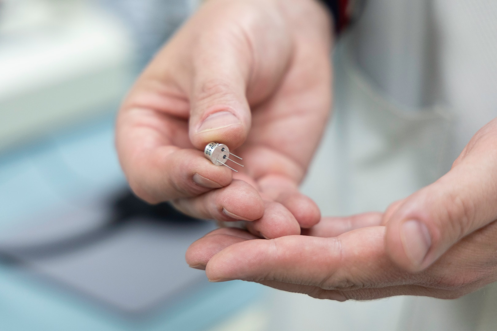 Rob Retkofsky, a technician in the Product Test Center’s electronics testing lab, holds a microcircuit during a demonstration Aug. 21 for Air Force Maj. Gen. David Sanford, the Defense Logistics Agency’s logistics operations director.