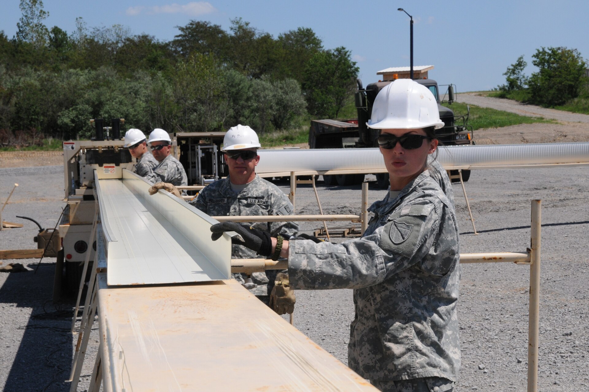Spc. Rachel Marcum from Louisa, Ky., with the 149th Vertical Engineer Company, guides a steel panel from an automatic building machine during a construction course at Wendell H. Ford Regional Training Center in Greenville, Ky., Aug. 20, 2012.