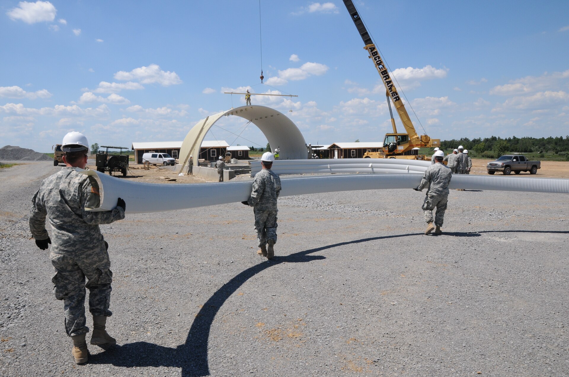 Soldiers of the 149th Vertical Engineer Company carry a steel panel to lift into position as the roof of a K-span building at Wendell H. Ford Regional Training Center in Greenville, Ky., Aug. 20, 2012.