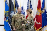 Space Force Lt. Col.  Ellie Constantine-Barredo (right) affixes the colonel rank insignia to Air Force Col. Alexander Constantine’s uniform during his frocking ceremony at the DLA Land and Maritime Operations Center Aug. 29.