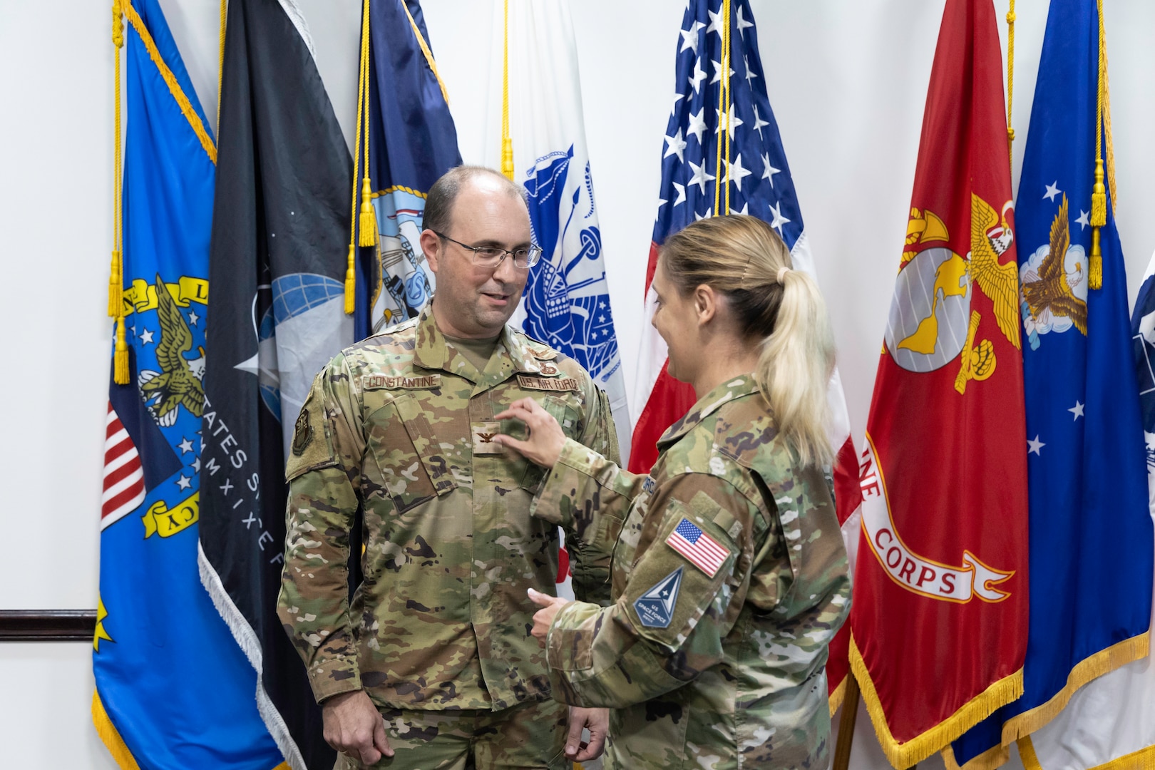Space Force Lt. Col.  Ellie Constantine-Barredo (right) affixes the colonel rank insignia to Air Force Col. Alexander Constantine’s uniform during his frocking ceremony at the DLA Land and Maritime Operations Center Aug. 29.