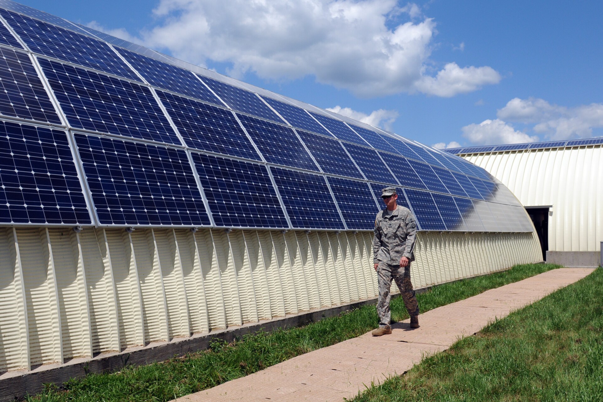 Sgt. Joseph Mattingly of Charlie Company, 1st Battalion, 376th Aviation walks between barrack buildings at the Harold L. Disney Training Center in Artemus, Ky., June 7, 2012. Solar panels installed on the buildings at the center are responsible for producing all the energy needed to power the buildings for use by units training at the site.