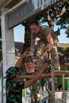 U.S. Army Sgt. 1st class Kelly Carter, construction engineering supervisor with the 610th Engineer Support Company and members of the Indonesian Armed Forces work together to finish renovation of an elementary school in Indonesia on Aug. 27, 2024.