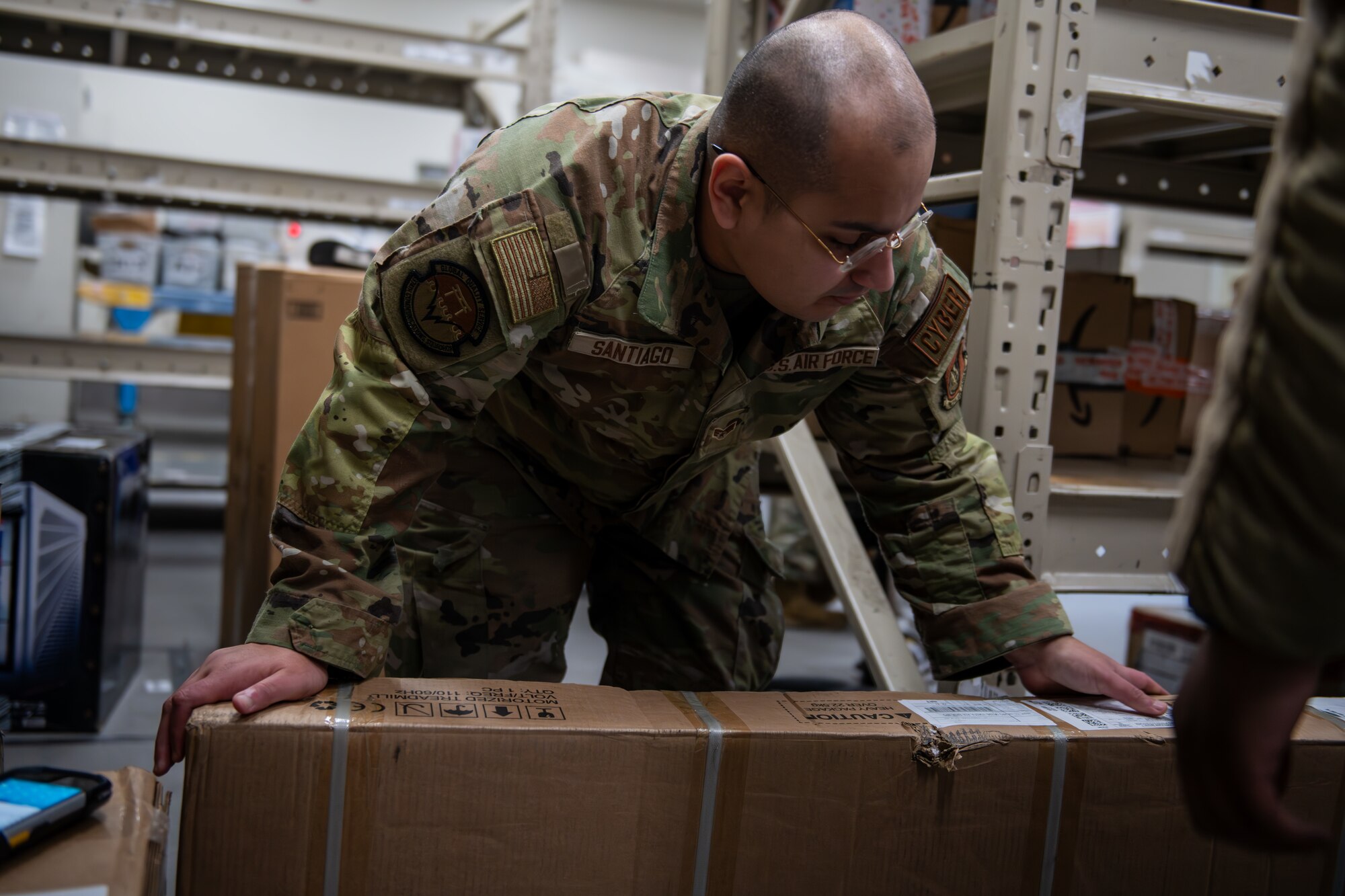 An Airmen pushes a box onto a cart